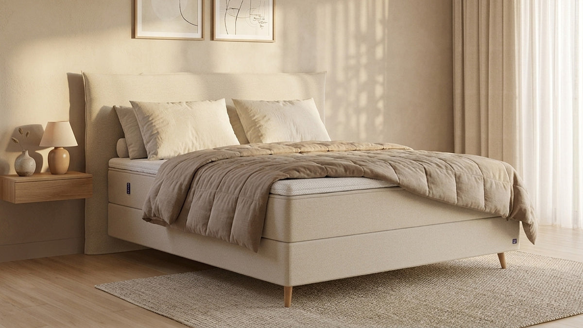 Bruno Boxspringbett mit Pillow-Kopfteil, in Beige, Winkelansicht, im Wohnraum, mit Topper, mit Füßen aus nordischer Eiche