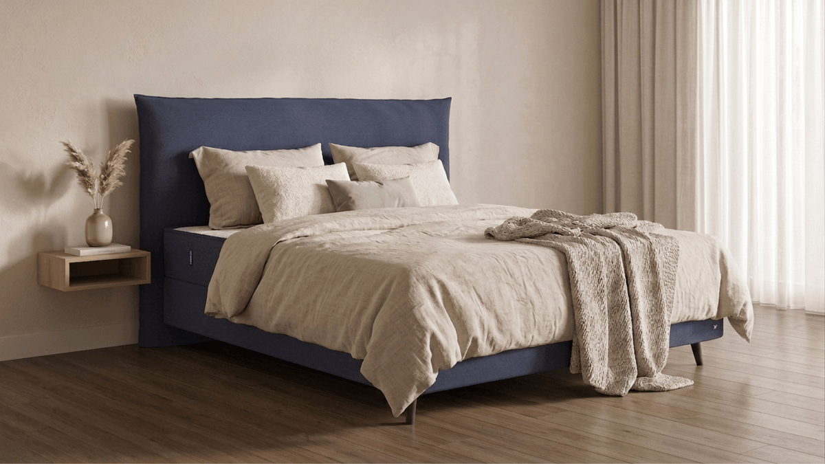 Bruno Boxspringbett mit Pillow-Kopfteil, in Blau, Winkelansicht, im Wohnraum, mit Füßen aus nordischer Eiche