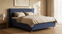Bruno Boxspringbett mit Pillow-Kopfteil, in Blau, Winkelansicht, im Wohnraum, mit Topper, mit Füßen aus nordischer Eiche